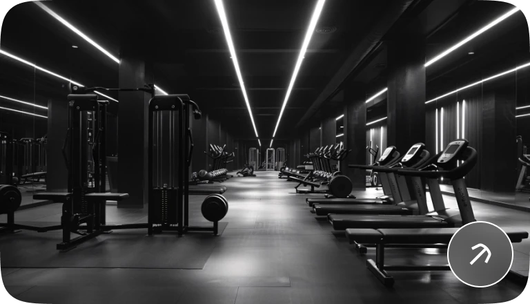 A gym with strength equipment and illuminated ceiling strips